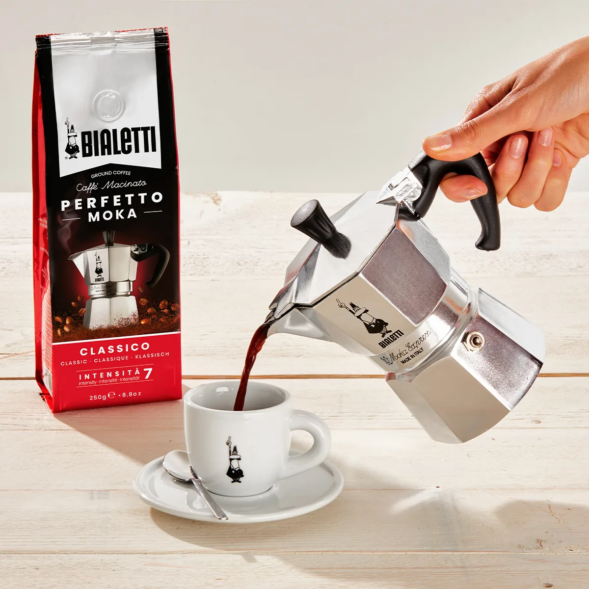 Kaffee wird aus einer Bialetti Moka Express in eine Tasse gegossen