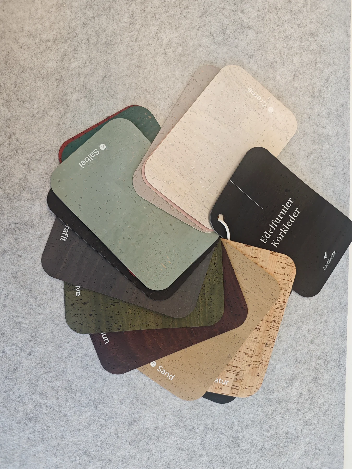 Nahaufnahme eines CLARISSAKORK-Musterfächers mit hellen, grünen, roten und dunklen Korkleder-Oberflächen